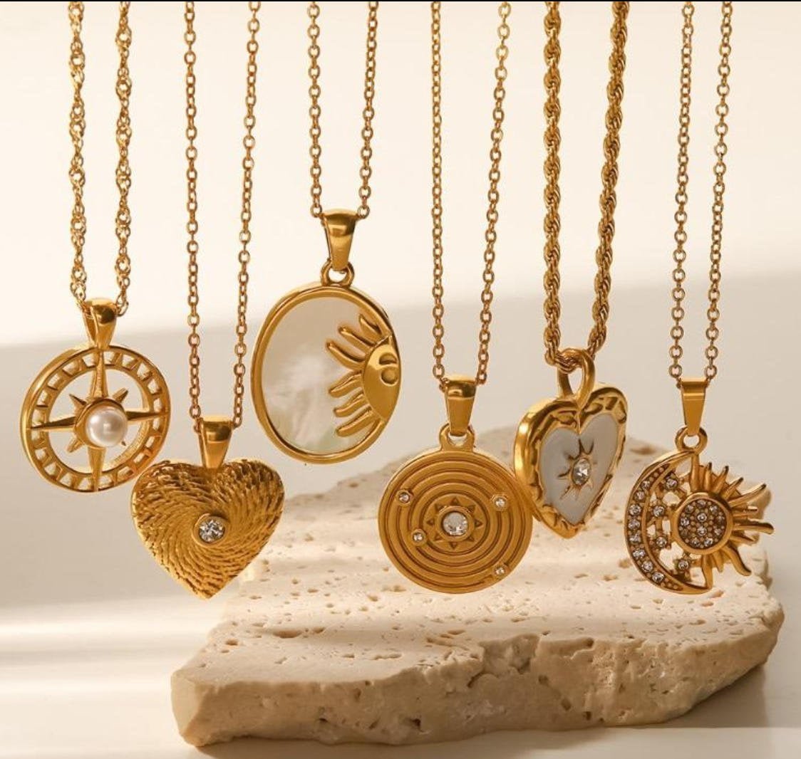 Stainless steel jewelry collection -- rings, necklaces, and bracelets displayed on a dark surface
