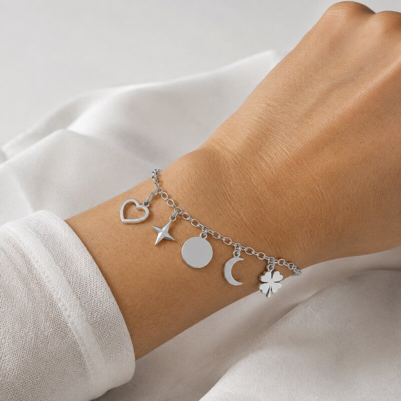 Women's stainless steel charm bracelet with five charms worn on the wrist