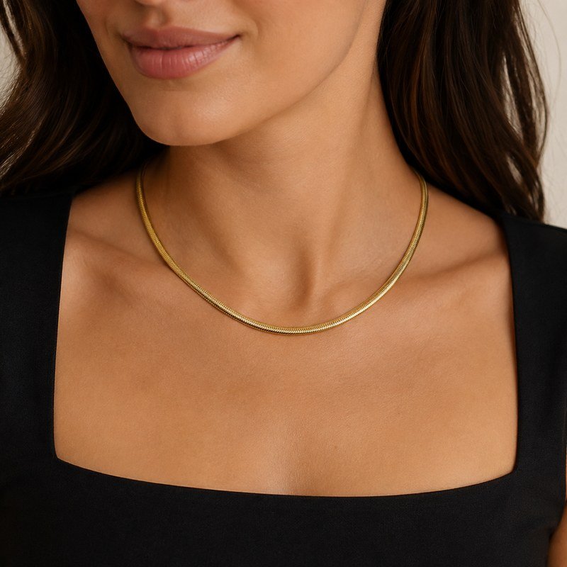Female model wearing a polished gold stainless steel snake chain necklace