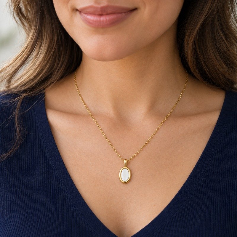 Woman wearing a gold Stainless Steel oval white enamel necklace