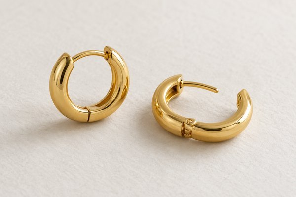 small gold stainless steel huggie hoop earrings: one open hoop clearly showing hinge and post