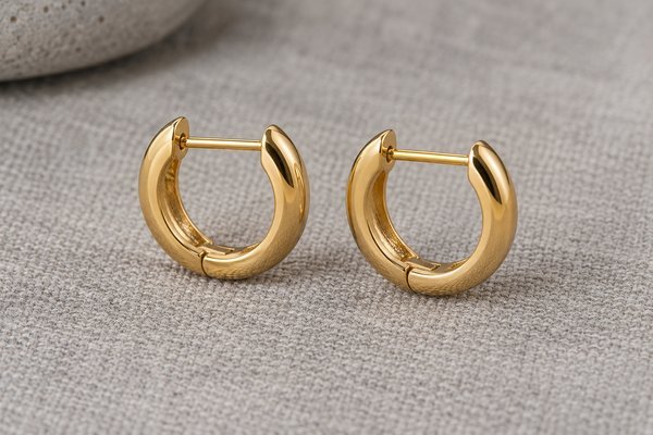 small gold stainless steel huggie hoop earrings: a pair photographed side-on showing post alignment